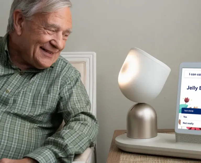 Older gentleman smiling with ElliQ AI companion
