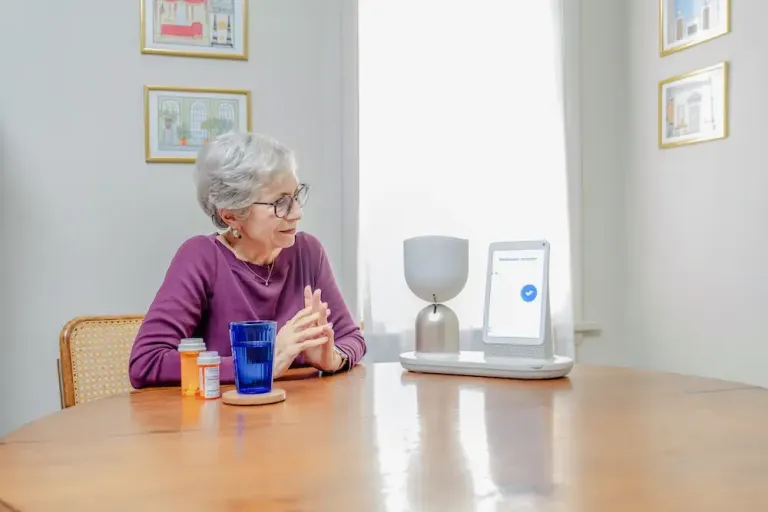 Older adult using ElliQ companion device for medication reminders